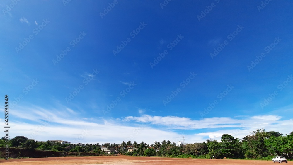 Obraz premium Brown field and blue sky and some greenery