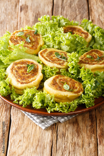 Fleischschnacka snails of meat, this French recipe from the Alsace serve with green salad close-up in a plate on the table. Vertical