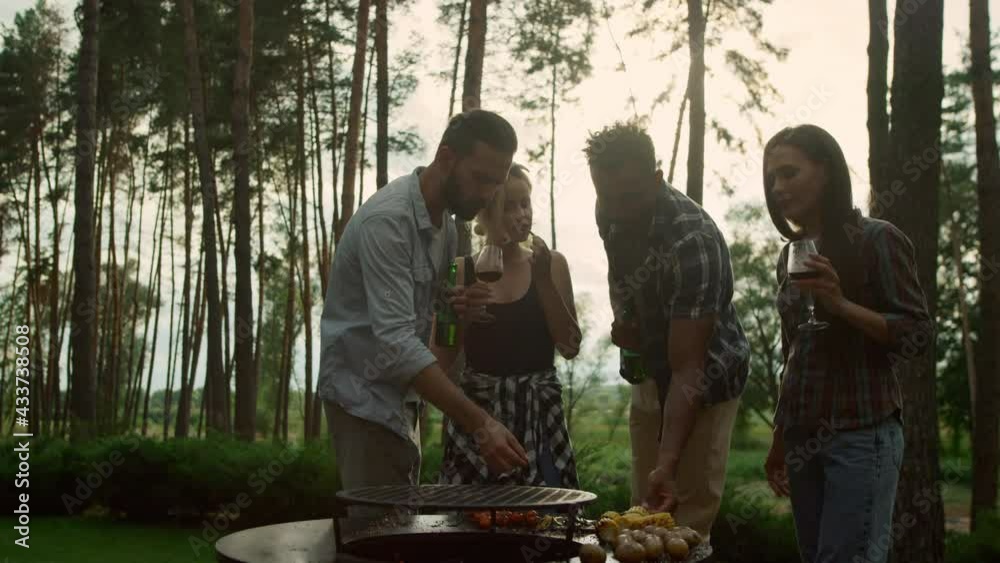 Relaxed people eating french beans in summer forest. Guys tasting bbq vegetables Relaxed people eating french beans in summer forest. Guys tasting bbq vegetables