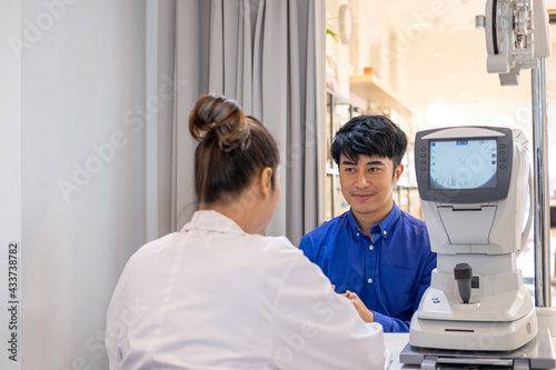 Selective focus at screen of Optometry equipment. While optometrist using subjective refraction to  examine eye visual system of young men patient with professional machine before made glasses.