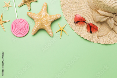 Photography Beach accessories, decorative starfish and lollipop on a green background with c