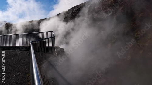 Steaming hot springs at Deildartunguhver in Reykholt, west Iceland, the hot spring with the highest flow in Europe, in winter season with colorful rocks and metal railing in front. photo