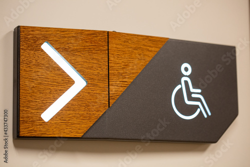 Closeup of PWD comfort room signage with an arrow sign showing the direction