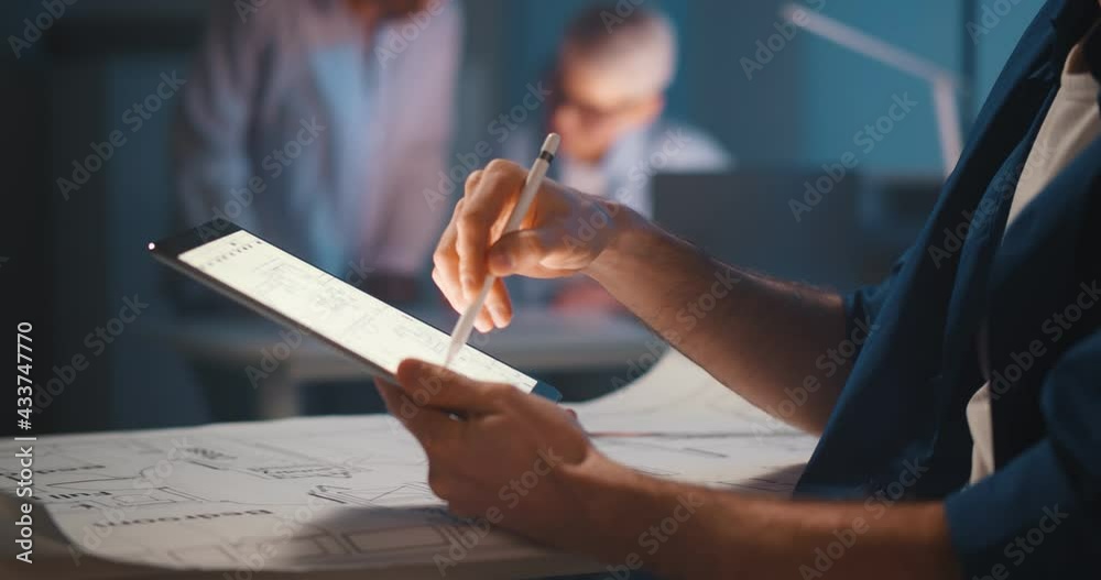 Cropped shot of woman at desk working on architectural plan using digital tablet