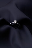 Diamond ring on black silk background with copy space