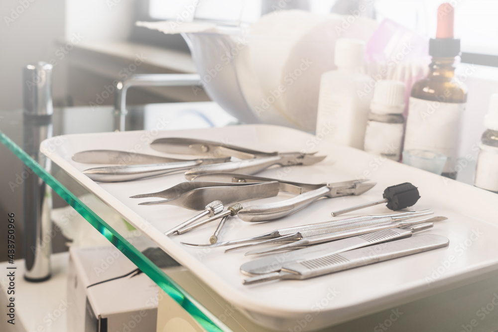 Medical instruments on a white tray. Chiropody tools. Nail nippers and nail rasps. Medical instruments on a white tray. Chiropody tools. Nail nippers and nail rasps.