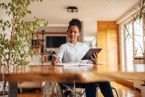 Canvas-taulu Woman in a wheelchair, working from home.