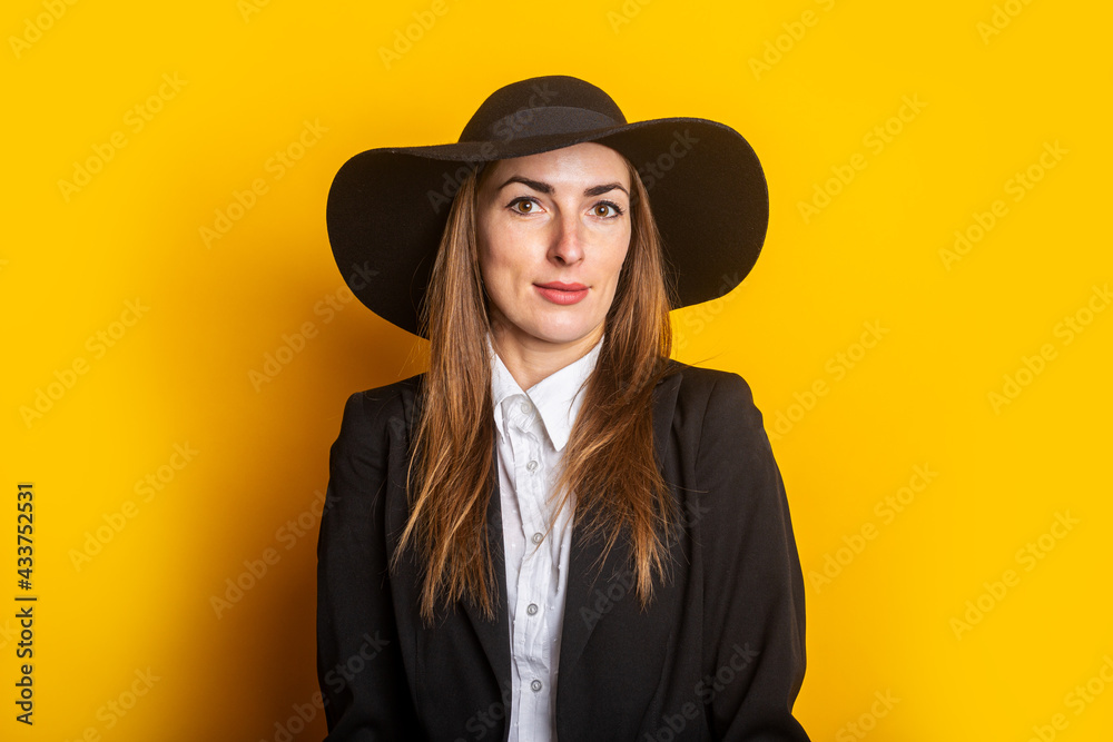 smiling business young woman in hat and jacket on yellow background smiling business young woman in hat and jacket on yellow background