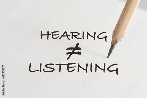 Hearing not equal listening written on white paper with pencil. Communication with understanding concept and soft skill idea