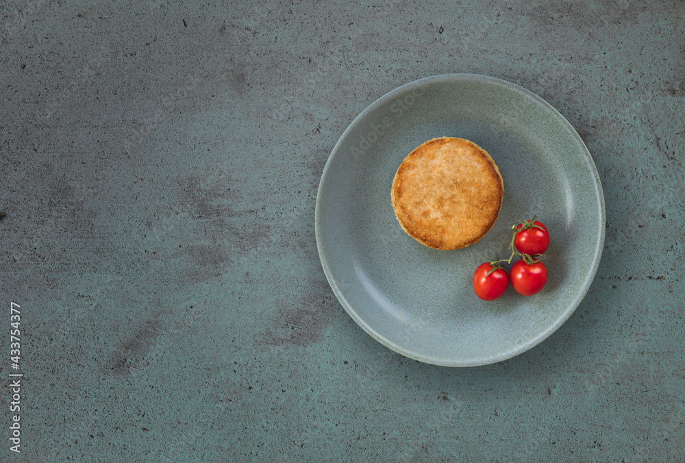 Meat chicken cutlet with cherry tomatoes on plate on textured background, copy space.