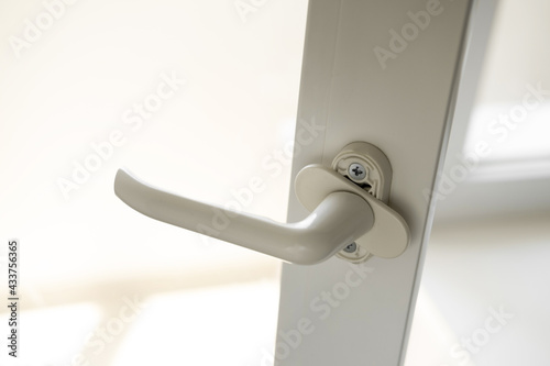 White pvc window or doorknob close-up. Adjusting the opening and closing of the plastic door.