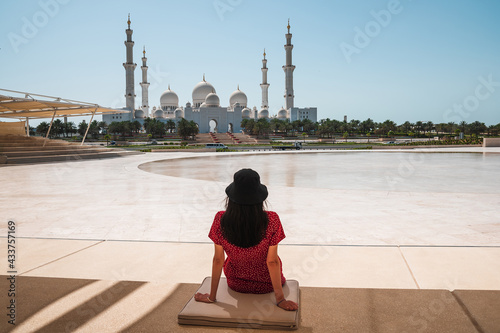 Woman enjoying view of Sheikh Zayed Grand Mosque in Abu Dhabi, United Arab Emirates on a sunny day photo
