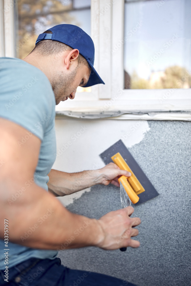 Man working on a house facade. Man working on a house facade.
