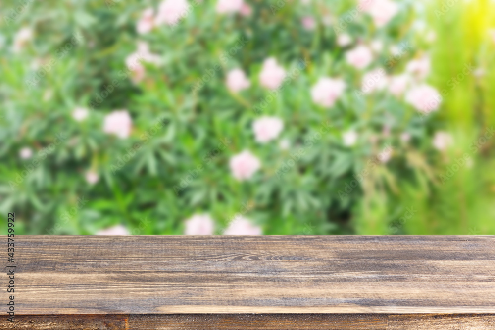 Fototapeta premium wood table top on blur bush with flowers background