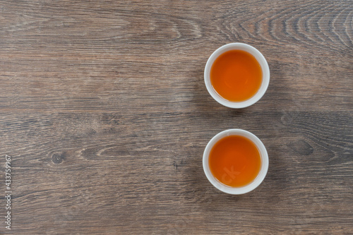 two white small tea bowls on wooden table, above minimalistic shot
