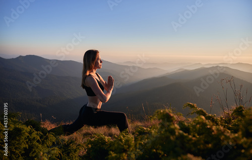 Canvas Print Side view of brunette practicing yoga in Warrior pose