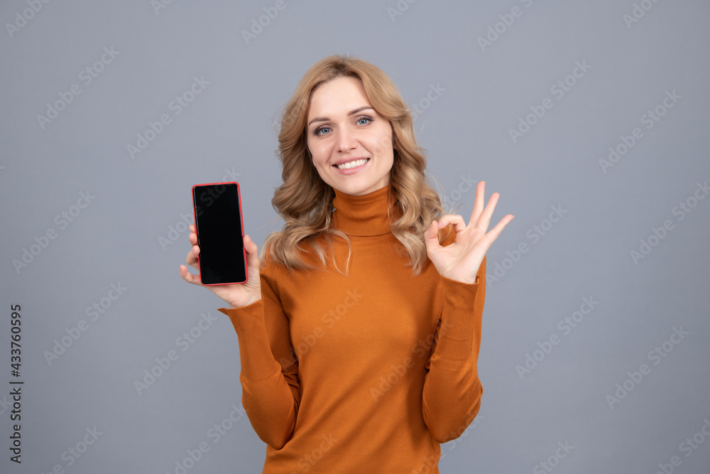 Approved mobile phone. Happy girl show OK sign to smartphone. Approved concept Approved mobile phone. Happy girl show OK sign to smartphone. Approved concept