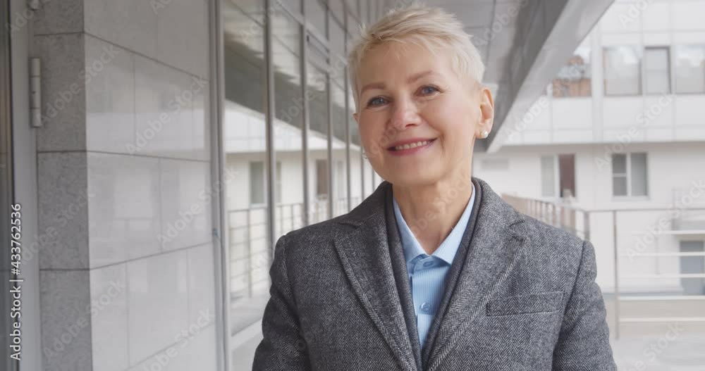 Close up portrait of mature professional businesswoman smiling outdoors business center Close up portrait of mature professional businesswoman smiling outdoors business center
