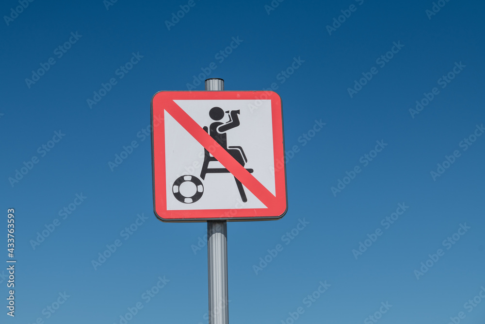 Unsupervised swimming sign on a blue sky Unsupervised swimming sign on a blue sky