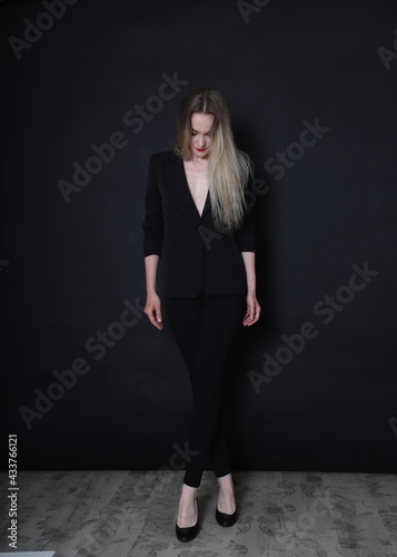 Photo of a fashion girl on a black background in black clothes light skin