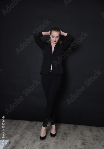 Photo of a fashion girl on a black background in black clothes light skin