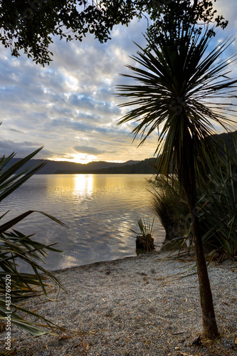 Lake Mapourika in New Zealand surrounded by nature, sunset with beautiful colourful cloudes photo