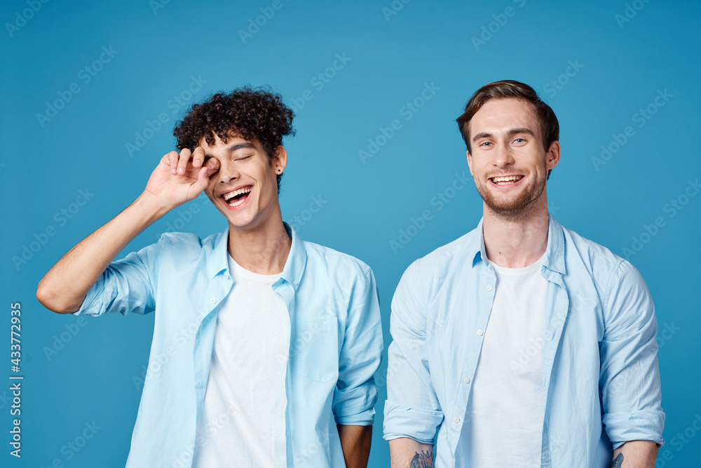 men in identical shirts and white t-shirts on a blue background chatting friends cropped view men in identical shirts and white t-shirts on a blue background chatting friends cropped view