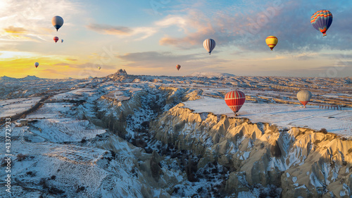 Hot air balloons fly over Cappadocia in winter, Goreme, Turkey. © tanarch