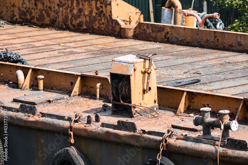 a hydraulic ship in the harbor of hamburg photographed in bright sunshine with strong colors and rusty textures