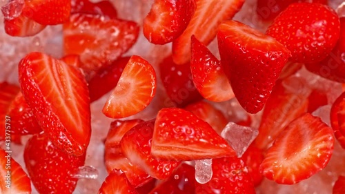 Super Slow Motion Shot of Fresh Strawberries and Crushed Ice Flying Towards Camera at 1000fps. photo