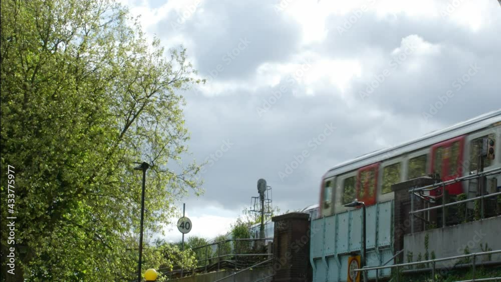 tube train passes over a road bridge heading into the city. tube train passes over a road bridge heading into the city.