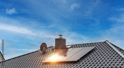 Hausdach mit schwarzen Dachziegeln und Photovoltaikanlage photo