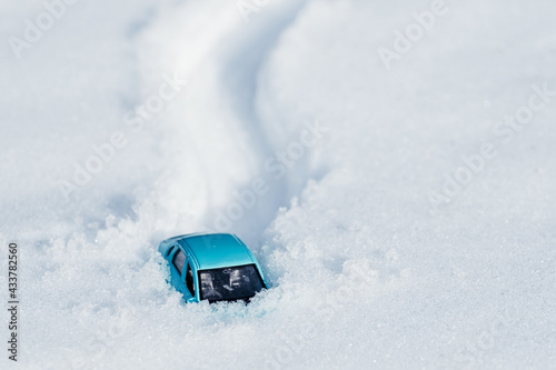 footprints and a car in the snow, a car stuck in a large pile of snow photo