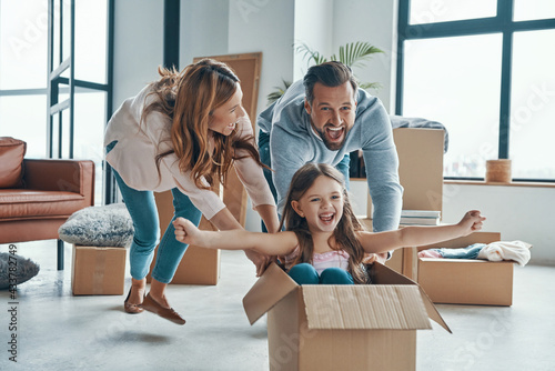 Family smiling and unboxing their stuff while moving into a new apartment photo