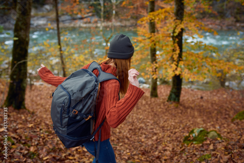 woman with backpack travel tourism forest landscape park river fallen leaves side view