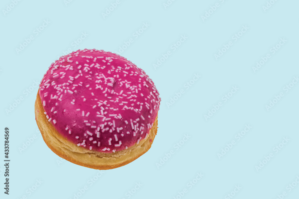 Close up view of pink donut sprinkled with white glaze isolated on blue background. Food and drink concept. Close up view of pink donut sprinkled with white glaze isolated on blue background. Food and drink concept.