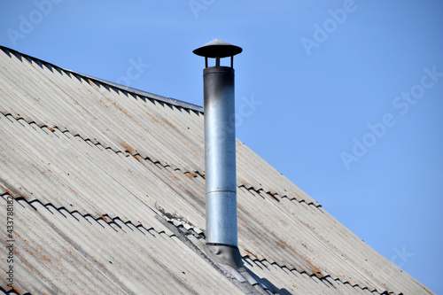 Fotografija Silver stove pipe in the house against the blue sky