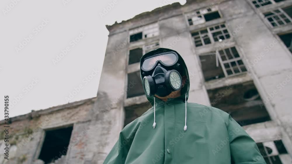 Woman in safety suit and respirator. Person in protective uniform during chemical attack in abandoned place. Nothing to breathe. Pollution of the environment.