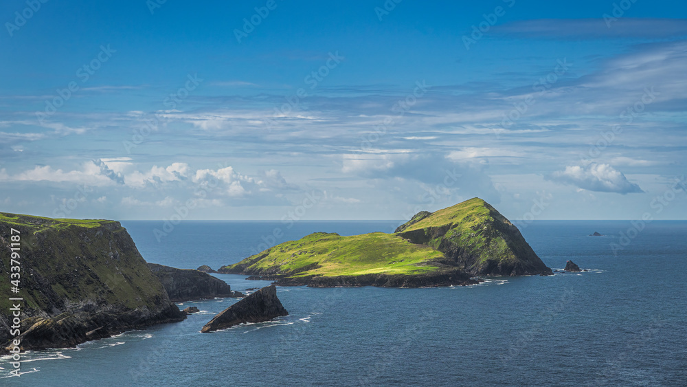 Rugged coastline with islands, Kerry Cliffs and blue waters of Atlantic Ocean on a summer day, Portmagee, Iveragh peninsula, Ring of Kerry, Ireland