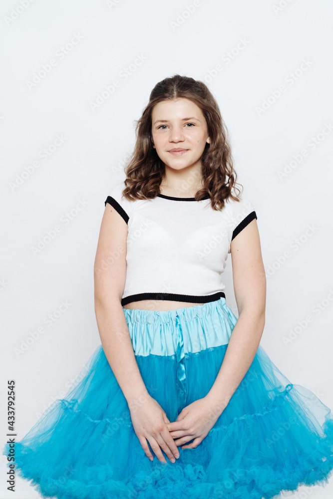 Happy stylish girl teenager posing with penny board on white background. Emotions concept Happy stylish girl teenager posing with penny board on white background. Emotions concept
