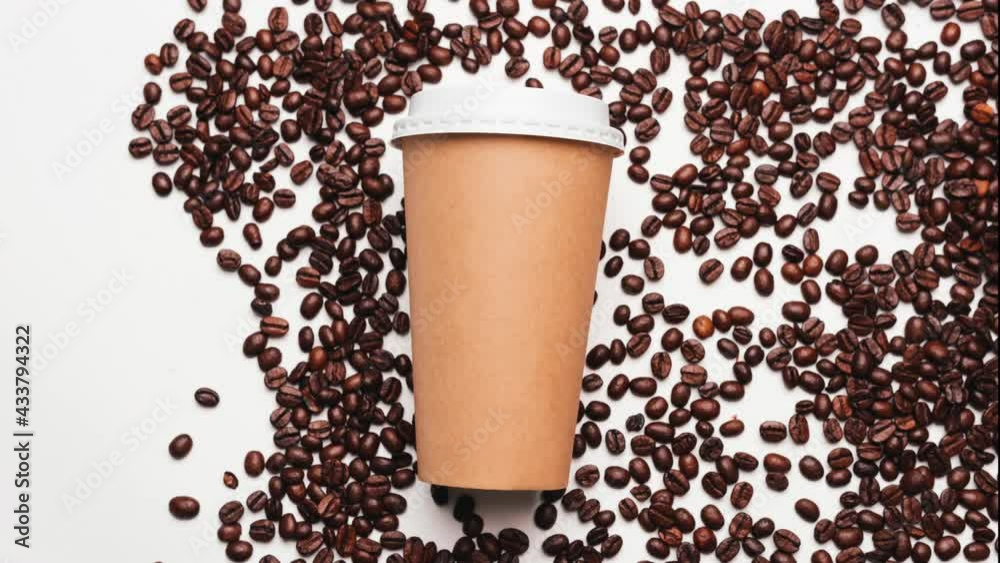 Stop motion video of paper coffee cup and fresh roasted coffee beans