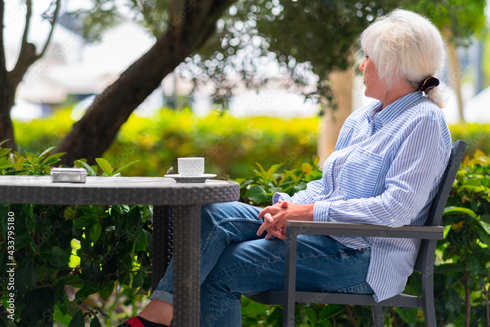 Pensive woman relaxing on an outdoor patio at a restaurant table Pensive woman relaxing on an outdoor patio at a restaurant table
