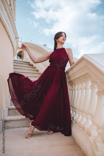 Konstfotografi Ragazza con vestito rosso lungo su un terrazzo
