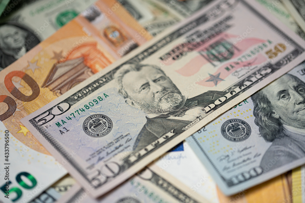 Fifty dollar bills next to euro bill. Currency exchange concept from euro to US dollar money. Fifty dollar bills next to euro bill. Currency exchange concept from euro to US dollar money.