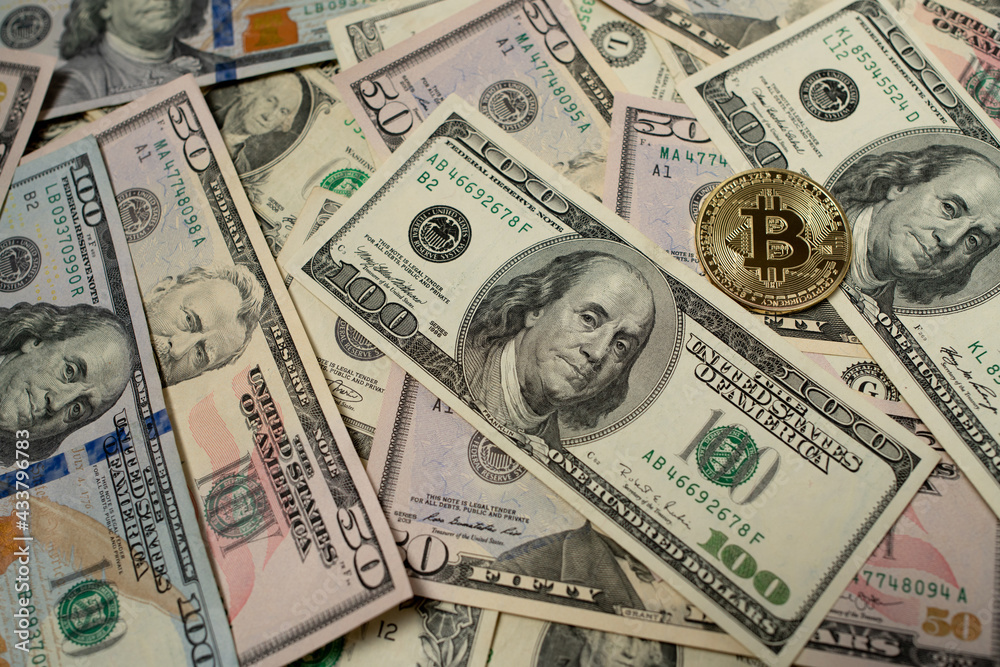 Bitcoin on dollar banknotes. One hundred dollar bill next to gold bitcoin coin. Crypto exchange concept