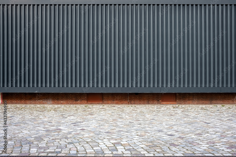 black corrugated sheet metal aluminum facade and concrete wall of a