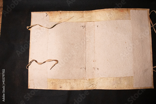 Fotografie A medieval manuscript hand written onto parchment or vellum and illuminated with red initial flourishes in pen