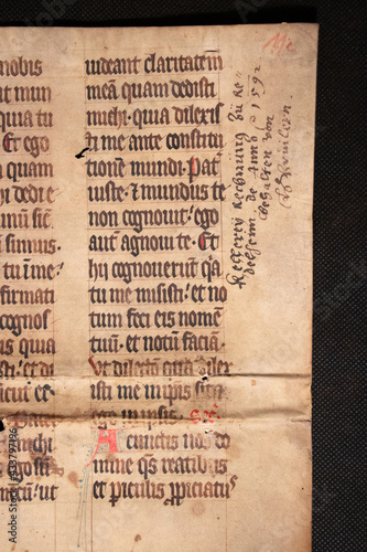 Fototapet A medieval manuscript hand written onto parchment or vellum and illuminated with red initial flourishes in pen