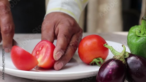 Close up shot of man hands slicing   tomato