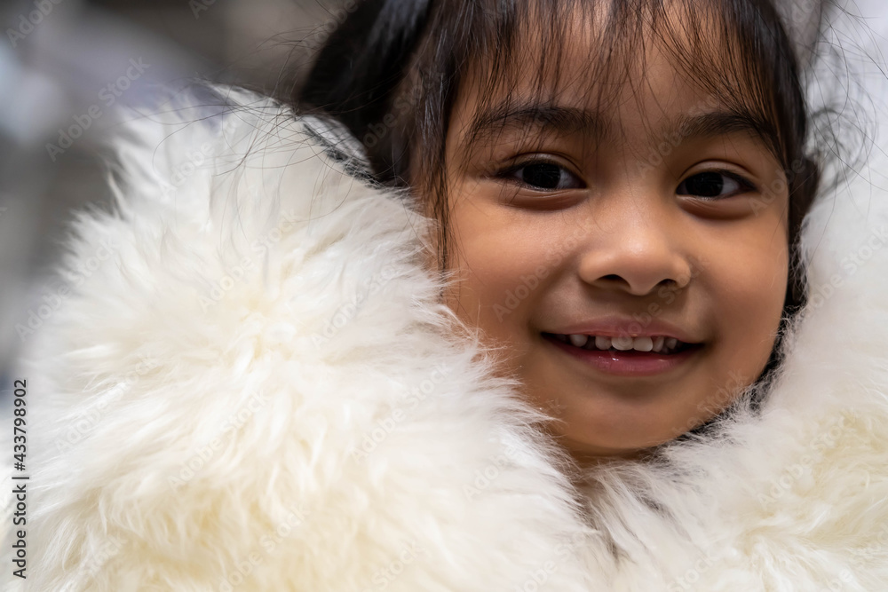 Pretty asian child wearing a white coat made of fur. Pretty asian model wearing white fur coat Pretty asian child wearing a white coat made of fur. Pretty asian model wearing white fur coat